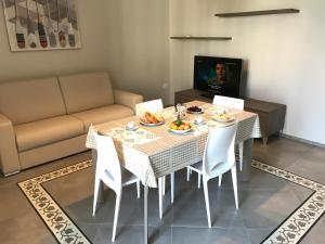 una sala da pranzo con tavolo, sedie e divano di Casa Vacanze La Scalinata a Bisceglie