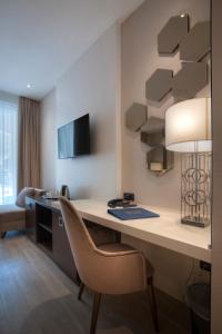 a hotel room with a desk and a chair at Hotel Riva by Aycon in Petrovac na Moru