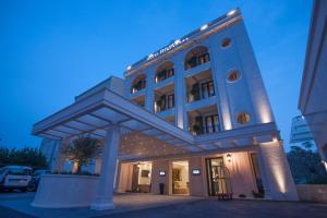 a large building with a lit up facade at Hotel Riva by Aycon in Petrovac na Moru