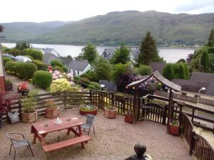 a patio with a table and chairs and a view of the water at Melrose in Fort William
