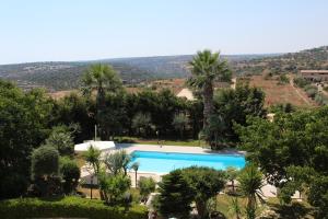 uma imagem de uma piscina com palmeiras em Villa Orchidea Luxury B&B em Ispica