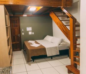 a small room with a bunk bed and a ladder at Pousada Bronzatto in Garopaba