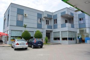 un edificio azul con dos coches estacionados en un estacionamiento en Hotel Alpet en Rinas