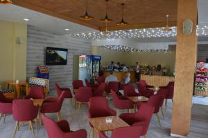 a restaurant with red chairs and a bar at Hotel Alpet in Rinas