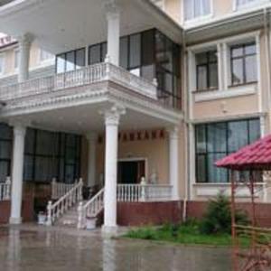 a large building in the rain with water on the ground at Эдельвейс in Almaty