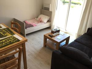 a living room with a couch and a table with a baby crib at La Villa aux Oliviers in Le Val +53 photos