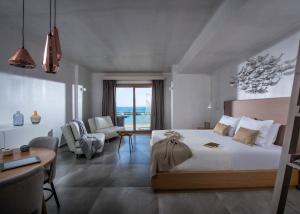 sypialnia z łóżkiem i salon ze stołem w obiekcie Cosmopolis Crete Suites w mieście Hersonissos