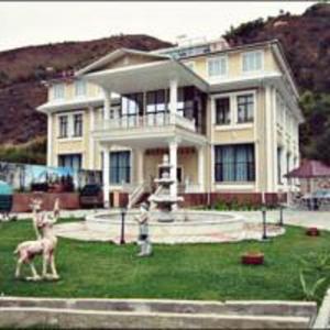 a house with a statue of a deer in front of it at Эдельвейс in Almaty