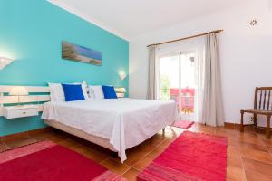 a blue and white bedroom with a bed and a window at Vila Graciosa - Tranquility Oasis in Lagos