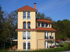 a large yellow house with a red roof at Meereszeichen in Baabe
