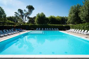 a swimming pool with lounge chairs at Hotel Gasparina in Castelnuovo del Garda