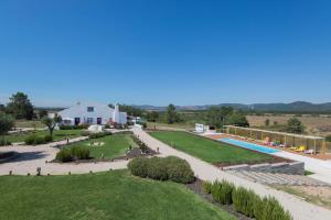 uma vista para um jardim com uma piscina e uma casa em Monte da Corça Nova em Vila Nova de Milfontes