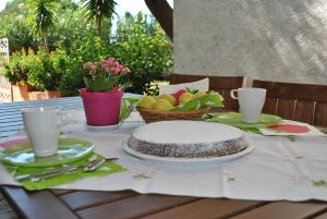パリヌーロにある"Parva sed apta mihi", Casa Stella a Palinuroのケーキとフルーツのバスケット付きのテーブル