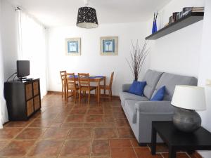 ein Wohnzimmer mit einem Sofa und einem Tisch in der Unterkunft Apartamentos Medano - Atico Playa in El Médano