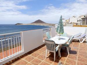 a balcony with a table and chairs and the ocean at Apartamentos Medano - Atico Playa in El Médano