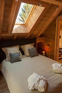 a bedroom with a large white bed with a window at La Cabane de Tim in Muhlbach-sur-Munster
