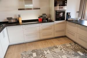 a kitchen with white cabinets and black counter tops at La Cabane de Tim in Muhlbach-sur-Munster