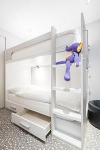 ein Schlafzimmer mit einem Etagenbett mit einem lila Spielzeug in der Unterkunft Hôtel Le White - Le 42 Restaurant in Champéry