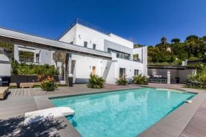a white house with a swimming pool in front of it at Villa Louancelie B&B in Cavalaire-sur-Mer