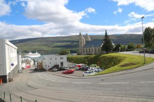 una strada con una chiesa e le auto parcheggiate in un parcheggio di K16Apartments ad Akureyri