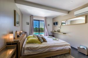 a bedroom with a large bed and a window at Villa Louancelie B&B in Cavalaire-sur-Mer