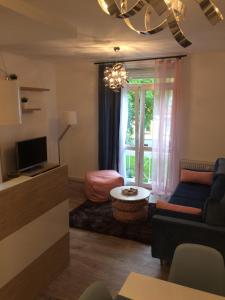 a living room with a couch and a window at Apartament Zawiszy Czarnego 10 in Koszalin