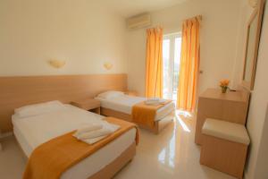 um quarto de hotel com duas camas e uma janela em Frixos Hotel em Malia