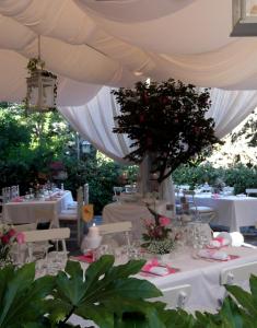 a table set up for a wedding under a white tent at Le Querce Hotel in Salsomaggiore Terme