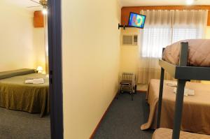 a hotel room with a bed and a television at Hotel Temu in Villa Carlos Paz