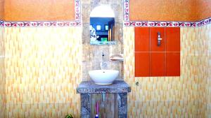 a bathroom with a sink and a red door at Saeri Matahari Bungalow in Gili Islands