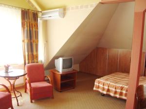 a bedroom with a bed and a tv and a table at Motel Zacisze in Łomża