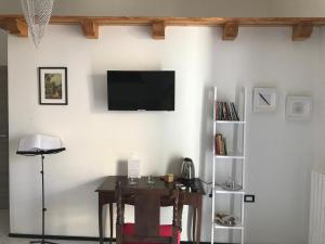 a room with a table and a television on a wall at Ca' del Borgo in Venosa