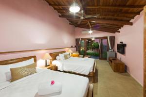 1 dormitorio con 2 camas y TV. en Wayan's Guesthouse, en Canggu