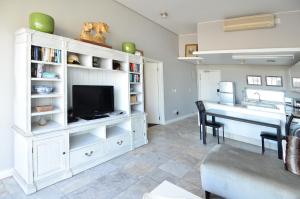 a living room with a tv and a dining room table at 410 Harbour Bridge in Cape Town