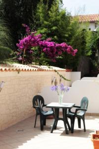 a table and chairs with purple flowers on a patio at Bed And Breakfast casagalez in Santa Domenica