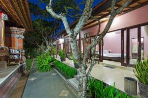 a house with a tree in the middle of a courtyard at Wayan's Guesthouse in Canggu