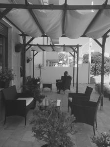 un patio con sofás y sillas bajo una sombrilla en Su Recreu, en Bosa Marina
