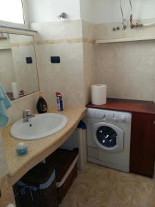 a bathroom with a sink and a washing machine at Appartamento Larghetto Licastro in Pizzo
