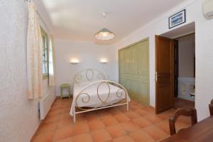 um quarto com uma cama branca num quarto em Les Lauriers Roses em Rayol-Canadel-sur-Mer