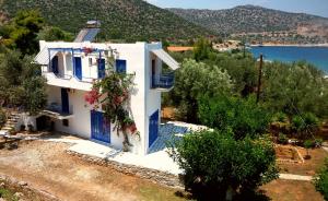 a white house with blue doors and a lake at Mouragio Studios in Tyros
