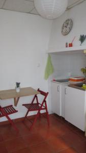 a kitchen with a table and a table and a clock at Casinha alentejana in Évora +2 photos