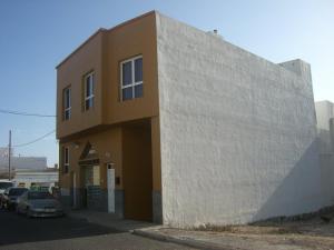 プエルト・デル・ロサリオにあるApartamento aeropuerto playaの駐車場横の茶色と白の建物
