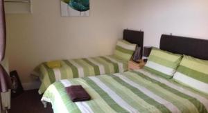 A bed or beds in a room at Albany Guest House 