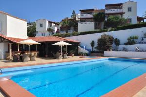 a swimming pool in front of a building at Castri Village Hotel in Palekastron