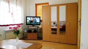 a living room with a television and a wooden door at Eko Apartment Sarajevo in Sarajevo