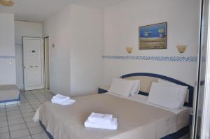 a bedroom with a bed with towels on it at Castri Village Hotel in Palekastron