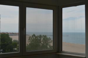コンスタンツァにあるApartament Faleza Nordのビーチを望む窓3つが備わる客室です。