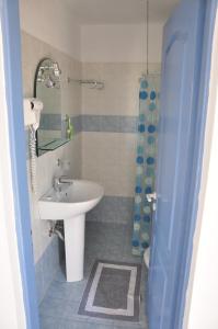 a bathroom with a white sink and a shower at Castri Village Hotel in Palekastron