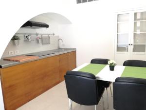 cocina con mesa, sillas y barra en Casa Vacanze Rosalia - affitto breve, en Santo Stefano di Camastra