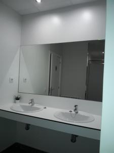 a bathroom with two sinks and a large mirror at Albergue Camiño Do Sar in Padrón